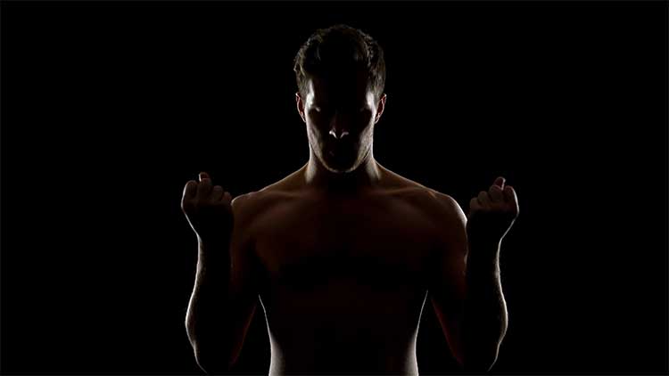 Male sportsman warming up before training, isolated on black background