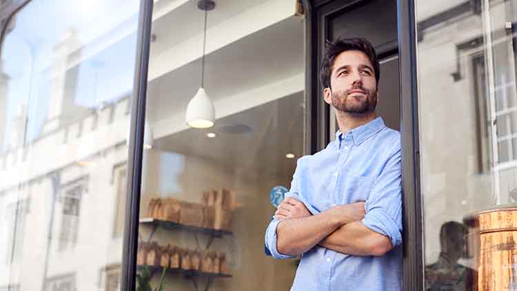 Portrait Of Male Owner Standing Outside Coffee Shop
