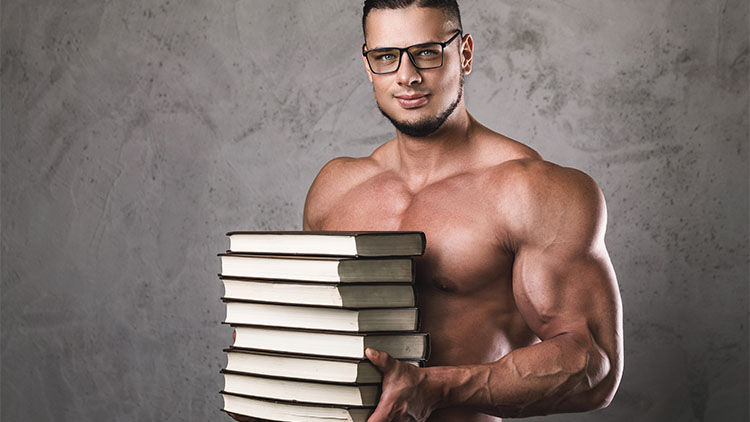 Smart and muscular man with a heap of books