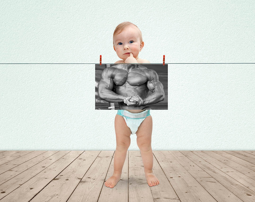 small child stood in front of image of muscular man